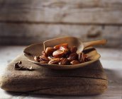 Dates and walnuts in rustic wooden bowl — Stock Photo