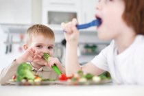Crianças comendo juntas à mesa — Fotografia de Stock