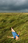 Девушка отдыхает в поле высокой травы — стоковое фото
