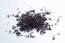 Feuilles de thé pile sur blanc — Photo de stock