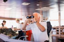 Captain on ship looking through a telescope — Stock Photo