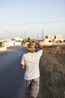 Visão traseira do homem andando na estrada rural — Fotografia de Stock