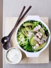 Салат с курицей и авокадо и соус в мисках — стоковое фото