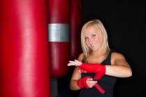 Boxeadora envolviendo sus manos en el gimnasio - foto de stock