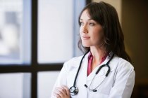 Female Doctor looking out window — Stock Photo
