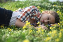 Женщина, лежащая в поле цветов — стоковое фото