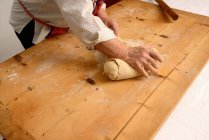Woman kneading dough on board — Stock Photo