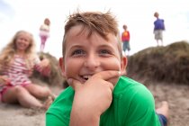 Portrait de garçon avec la main sur le menton souriant, Pays de Galles, Royaume-Uni — Photo de stock