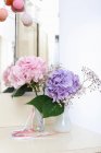 Colorful flowers in glass vase on table — Stock Photo