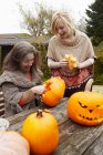 Mother and daughter carving pumpkins — Stock Photo
