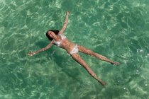 Femme flottant dans la mer tropicale — Photo de stock
