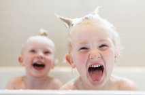 Bebés riendo en el baño - foto de stock