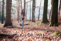 Mujer mayor caminando en el bosque - foto de stock