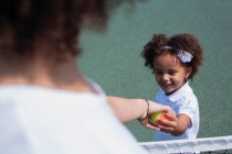 Mother and daughter playing on court — Stock Photo