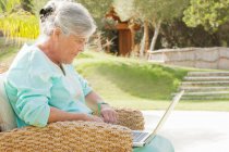 Ältere Frau benutzt Laptop im Freien — Stockfoto