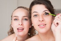 Adolescentes aplicando maquillaje, se centran en el primer plano - foto de stock