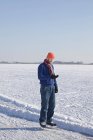 Людина в льодових ковзанах за допомогою мобільного телефону — стокове фото