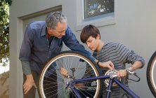 Vater hilft Sohn bei Reparatur von Fahrrad — Stockfoto