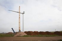 Wind turbine erecting with crane in industrial landscape — Stock Photo