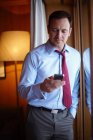 Empresário no telefone celular no quarto de hotel — Fotografia de Stock