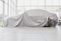 Niño mirando debajo de tela en el coche - foto de stock