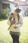 Jeune femme portant un chapeau, tenant un chat — Photo de stock
