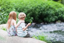 Children sitting on rock together — Stock Photo