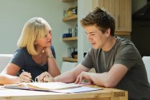 Mother helping son with homework — Stock Photo