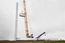 Grúa y turbina con ingenieros que trabajan en obras de construcción de parques eólicos - foto de stock
