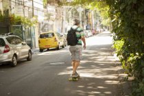 Vista trasera de hombre maduro skateboarding en la calle, Rio De Janeiro, Brasil - foto de stock