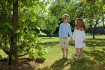 Children holding hands in backyard — Stock Photo