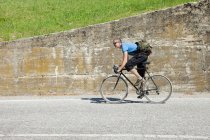 Vista laterale del ciclista pedalando in salita — Foto stock