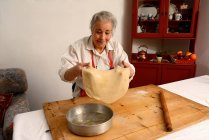 Donna anziana che allunga foglio di pasta — Foto stock