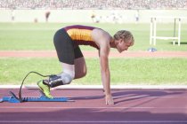 Sprinter masculino incapacitado em posição inicial no estádio — Fotografia de Stock