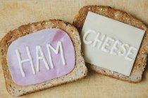 Vista superior de las palabras jamón y queso escrito en tostadas en mayonesa - foto de stock