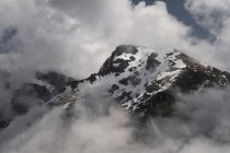 Nuages et montagne enneigée — Photo de stock