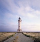 Sentier atteignant le phare avec ciel nuageux violet — Photo de stock