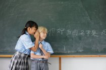 Шкільні діти діляться відповідями — стокове фото