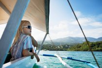 Mädchen entspannt sich in Boot auf stillem See — Stockfoto