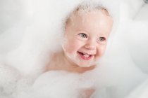 Toddler playing in bubble bath — Stock Photo