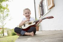 Дівчина грає на гітарі на відкритому повітрі — стокове фото