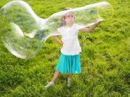 Маленька дівчинка робить мильні бульбашки — стокове фото