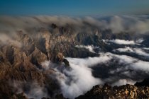 Туман котиться над скелястими горами — стокове фото