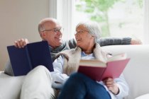 Посміхаючись старша пара читає книги — стокове фото