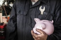 Vista parcial de perto do trabalhador que detém o banco porquinho — Fotografia de Stock