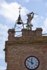 Statua fatiscente sulla torre dell'orologio con cielo nuvoloso sullo sfondo — Foto stock