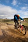 Чоловік їде на гірському велосипеді в бруді — стокове фото