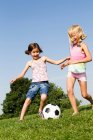 Девушки играют в футбол в поле — стоковое фото