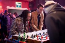 Men playing table football in bar — Stock Photo