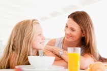 Madre hablando con su hija en el desayuno - foto de stock